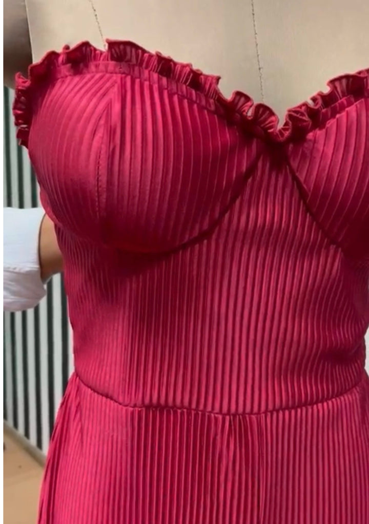 Close-up of a red pleated dress with ruffled neckline.