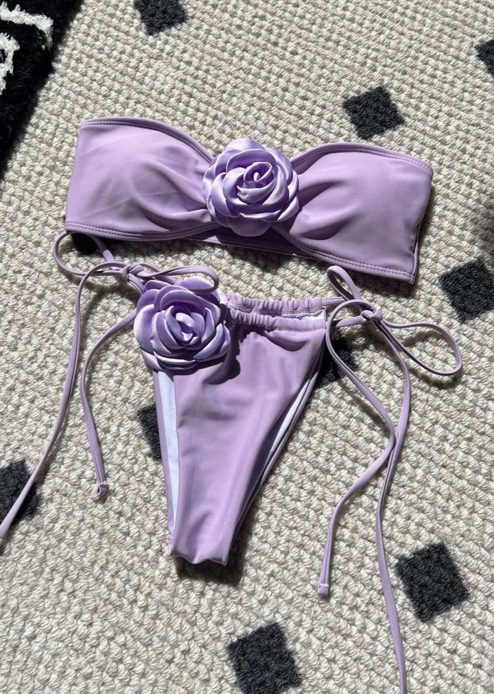 Lavender bikini set with floral details on a textured surface