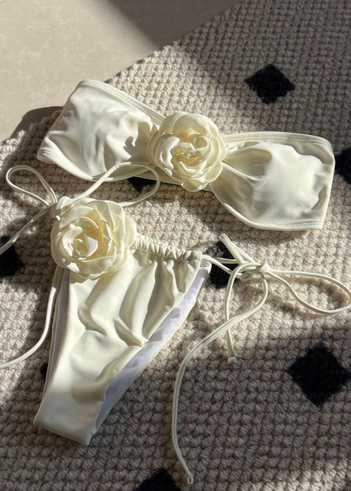 White satin lingerie set with floral details on a textured surface