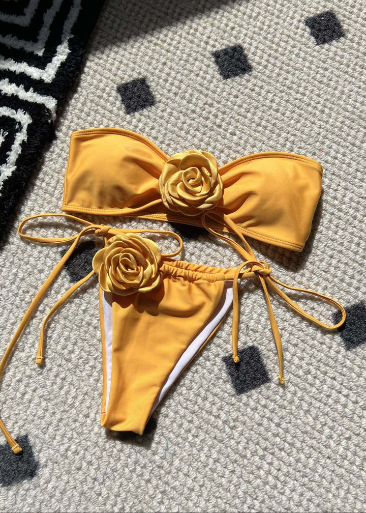 Yellow bikini with floral details on a textured surface