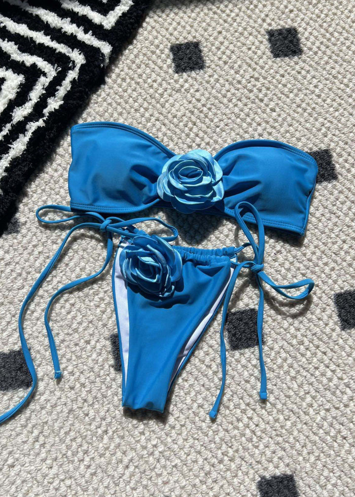 Blue bikini with floral details on a textured surface